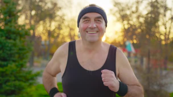 Ανώτερος άνθρωπος τρέχει στο δρόμο σε δημόσιο πάρκο. Υγιεινός τρόπος ζωής και άσκηση. — Αρχείο Βίντεο