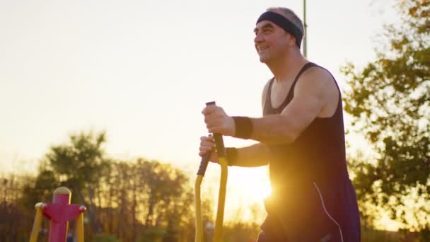 Hombre mayor haciendo ejercicio en el gimnasio y al aire libre. — Vídeos de Stock