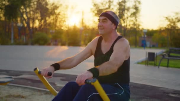 Hombre mayor haciendo ejercicio en el gimnasio y al aire libre. — Vídeos de Stock