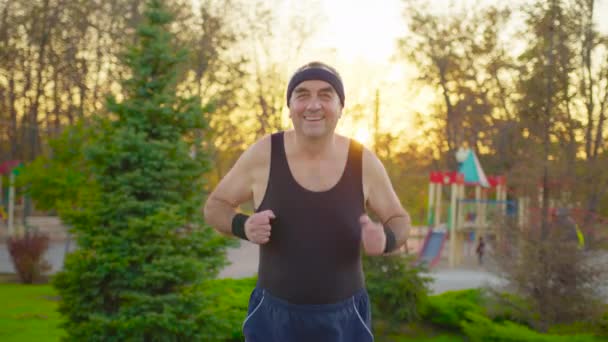 Senior man kör på väg i allmän park. Hälsa livsstil och motion Begreppet. — Stockvideo