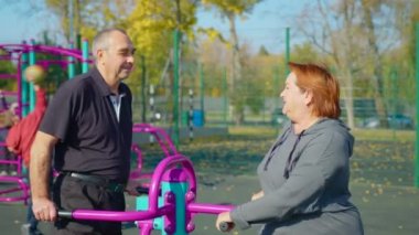 Dışarıdaki simülatörde spor yapan yaşlı bir çift. Emeklilik konsepti sırasında parkta ya da bahçede sağlık ve spor yapmak..