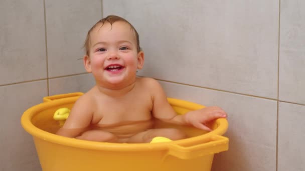 Video al rallentatore di adorabile bambina seduta e sorridente al bagno. — Video Stock