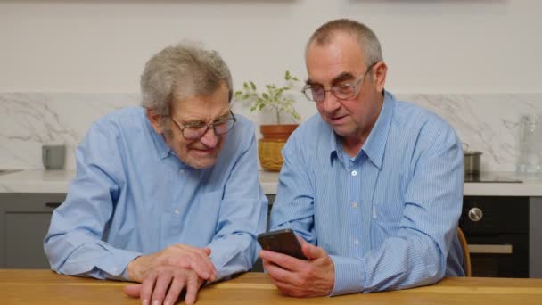 Anciano sonriente 80 abuelos adultos aprenden aplicación de teléfono móvil, feliz 70s senior man hold mensajes de texto de teléfonos inteligentes en las noticias de lectura de medios sociales, anciano utilizando el concepto de gadget de tecnología en casa — Vídeos de Stock