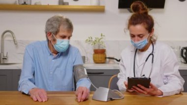 Sağlık ziyaretçinizden ve ev ziyareti sırasında üst düzey bir adam. Kadın bir hemşire ya da doktor bir adam incelenmesi.