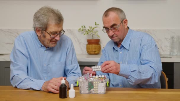 Dos hombres mayores eligen pastillas para el tratamiento — Vídeo de stock