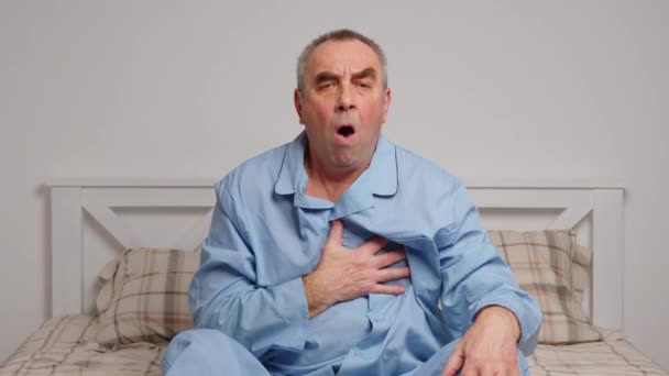 Ein älterer Mann im Bett leidet unter starken Schmerzen. Heimweh-Konzept — Stockvideo