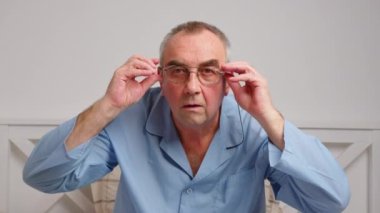 Yaşlı adam şok oldu ve şaşırdı. Şaşkınlık içindeki bir adam gözlüğe ateş eder ve kameraya şaşkınlıkla bakar..