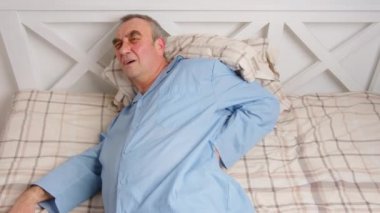 Yatakta yatan yaşlı bir adamın portresi. Ağrı ve sağlık hizmeti kavramı.