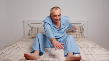 Yaşlı adam evde jimnastik egzersizleri yapıyor. Sağlıklı yaşam tarzı, fitness, eğlence, refah, emeklilik, yaşlılık kavramı.