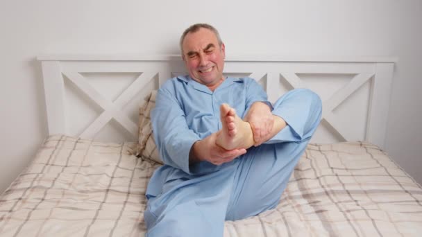 Yatakta yatan yaşlı bir adam şiddetli acıdan muzdarip. Ev hasreti kavramı — Stok video
