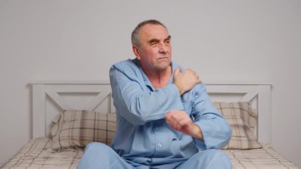 Starší muž v posteli trpí těžkou bolestí. Koncept domácí nemoci — Stock video