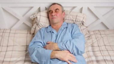 Yatakta yatan yaşlı bir adam şiddetli acıdan muzdarip. Ev hasreti kavramı