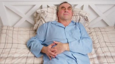 Yatakta yatan yaşlı bir adam şiddetli acıdan muzdarip. Ev hasreti kavramı