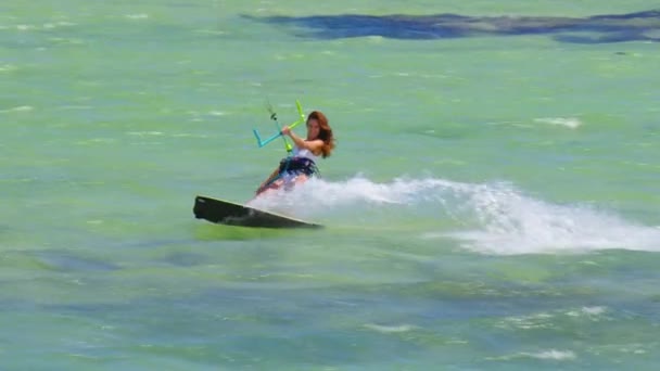 Krásná mladá dívka v bílých plavkách jezdí na vlnách na draka na čistém a průhledném oceánu — Stock video