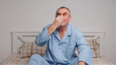 Yatakta yatan yaşlı bir adamın portresi. Ağrı ve sağlık hizmeti kavramı.