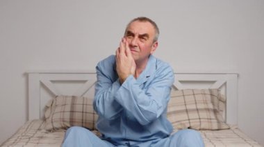 Yatakta yatan yaşlı bir adam şiddetli acıdan muzdarip. Ev hasreti kavramı