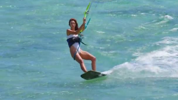 Bella ragazza kitesurf in costume da bagno bianco. Kiteboarding estremo al rallentatore. Sport d'azione divertenti estivi. — Video Stock