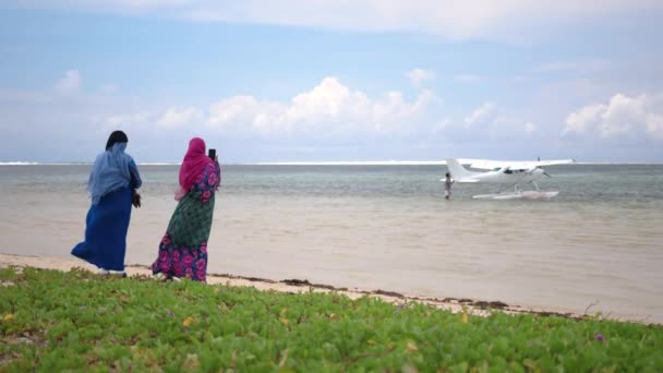 Women in a burqa with her head covered on the beach and looks out at the sea. Arab women take a photo of the ocean — Stock Video