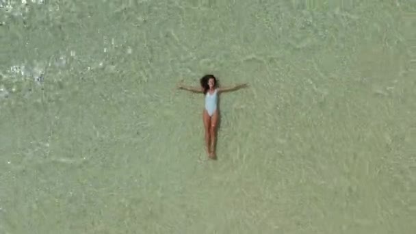 Widok z góry jako kobieta w białym stroju kąpielowym pływa w oceanie. Letni styl życia — Wideo stockowe