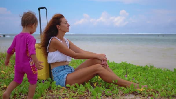 Woman with family and yellow suitcase on the beach — Vídeo de Stock