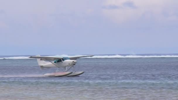 White sea plane landing in a calm lagoon — Vídeo de Stock