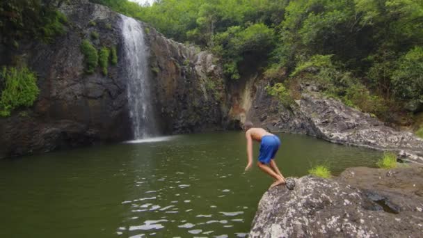 Slow motion footage of a boy jumping into a waterfall. — Vídeo de Stock