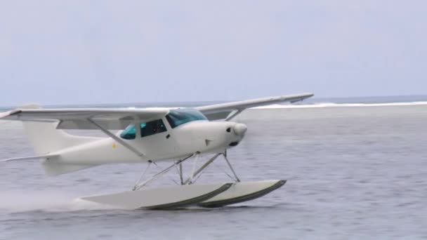 White sea plane landing in a calm lagoon — Stockvideo