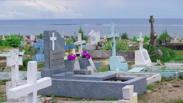 Taşlı sahilde haç taşları dalgaların kayalara çarpmasıyla duruyor. Okyanus kıyısındaki mezarlık — Stok video