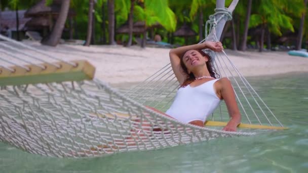 Femme se détendre dans l'hamac dans l'océan pendant les vacances tropicales. Concept de voyage. — Video