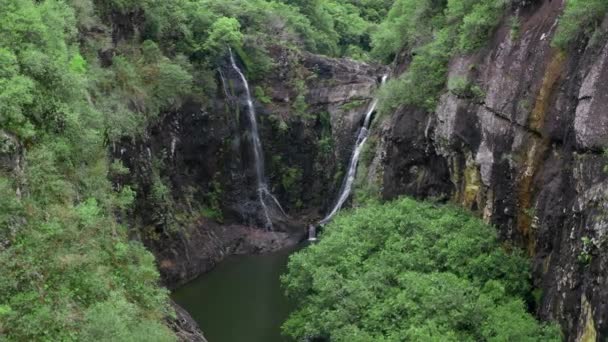 Kamera fliegt über Wasserfall im tropischen Wald. Luftaufnahme. Idyllischer Wasserfall und erstaunliche Natur. Sonnenlicht und wilder Teich im Urwald — Stockvideo