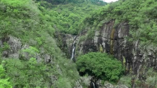 Kamera fliegt über Wasserfall im tropischen Wald. Luftaufnahme. Idyllischer Wasserfall und erstaunliche Natur. Sonnenlicht und wilder Teich im Urwald — Stockvideo