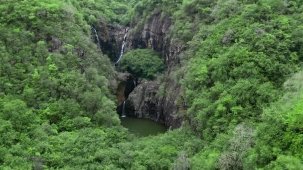 Camera is flying above waterfall in tropical forest. Aerial view. Idyllic waterfall and amazing nature. Sunlight and wild pond in jungle forest — Video Stock