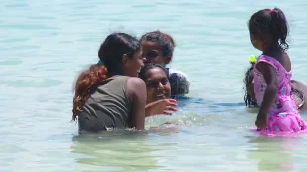 Маврикий, Blue Bay Beach, 18 января 2022 года: счастливая индийская семья купается в теплом океане с голубой водой. Люди индийской внешности проводят выходные на пляже со своими детьми — стоковое видео