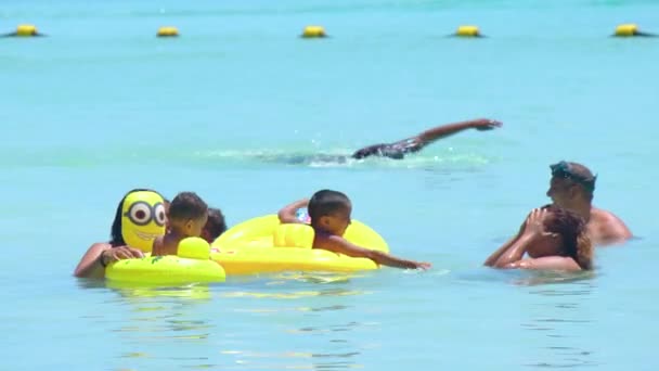 모리셔스, 블루 베이 비치 (Mauritius, Blue Bay Beach), 2022 년 1 월 18 일: 인도의 행복 한 가족 이 푸른 물 과 따뜻 한 바다에서 헤엄치고 있다. 인도 사람들은 자녀들 과 함께 해변에서 주말을 보낸다 — 비디오