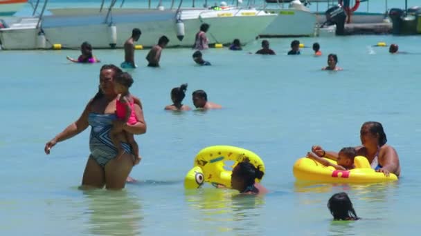 Маврикий, Blue Bay Beach, 18 января 2022 года: счастливая индийская семья купается в теплом океане с голубой водой. Люди индийской внешности проводят выходные на пляже со своими детьми — стоковое видео