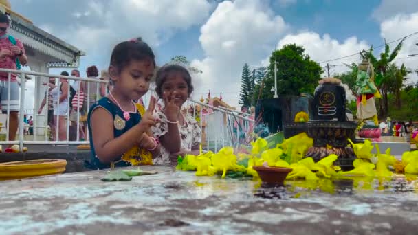 Mauricius, Ganga Talao, 18. ledna 2022: Indické rodiny v tradičním oblečení přišli k posvátnému jezeru Ganga Talao provádět rituály a klanět se bohům — Stock video