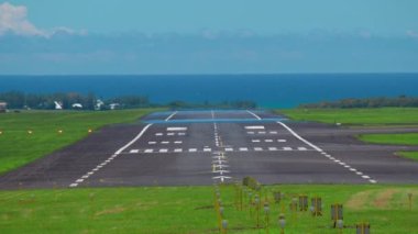 Kıtalararası büyük bir uçak Mauritius pistine çarpar. Mavi okyanusun arka planında havaalanına varan uçağın arka görüntüsü..