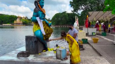 Mauritius, Ganga Talao, 18 Ocak 2022: Geleneksel giysiler içinde Hintli aileler kutsal Ganga Talao Gölü 'ne ayin yapmak ve tanrılara boyun eğmek için geldiler.