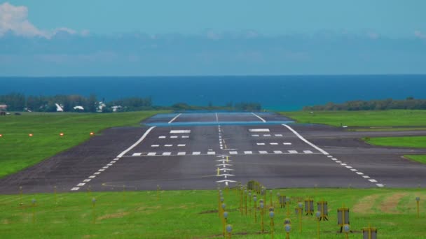 Egy nagy interkontinentális gép lezuhan Mauritius kifutópályáján. Hátsó nézet a repülőtérre érkező repülőgépről a kék óceán hátterében. — Stock videók