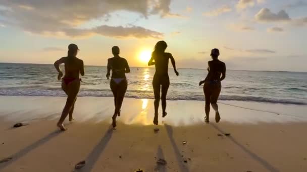 4人の女の子が走り、一緒にビーチでゆっくりと動き、ビーチで休暇中の幸せな女の子 — ストック動画