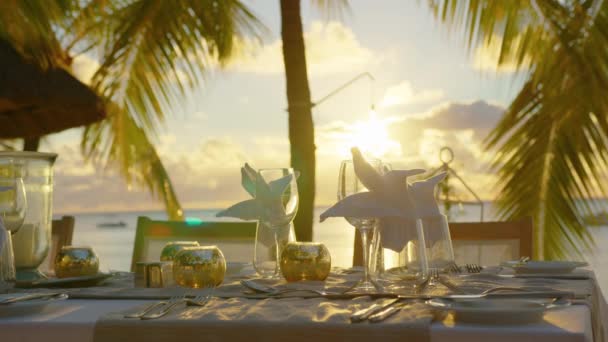 Romantischer Abendtisch für zwei Personen am Strand bei Sonnenuntergang vor dem Hintergrund schöner Wolken — Stockvideo