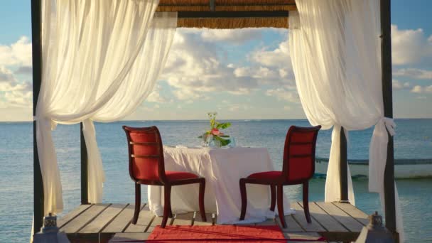 Romantisk middag på havsstranden i vatten mot underbar solnedgång på sommaren sandstrand under solnedgången — Stockvideo