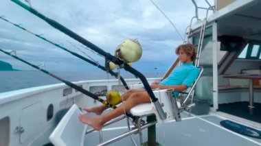 Sürat teknesinde bir balıkçı büyük bir balık ve ton balığı yakalar. Büyük balık avlama makaraları, oltalar ve oltalar