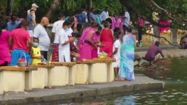 Mauritius, Ganga Talao, 18 Ocak 2022: Geleneksel giysiler içinde Hintli aileler kutsal Ganga Talao Gölü 'ne ayin yapmak ve tanrılara boyun eğmek için geldiler.