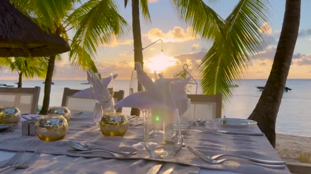 Romantikus vacsora a tengerparton víz ellen csodálatos naplemente nyáron homokos tengerpart napnyugtakor — Stock videók
