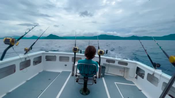 A fisherman on a motorboat catches a big fish of marlin and tuna. Big game fishing reels and rods reels and rods. Point of view POV close shot from back of a yacht in deep ocean. — Stock Video