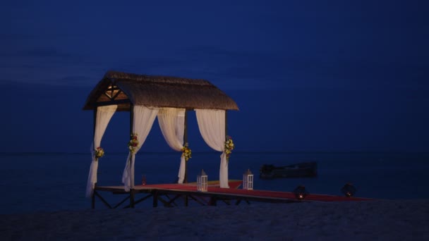 Playa nupcial preparada para la playa. Arco de boda en la orilla del Océano Índico decorado con flores. Concepto de vacaciones. Boda patrones de eventos isla al atardecer — Vídeos de Stock