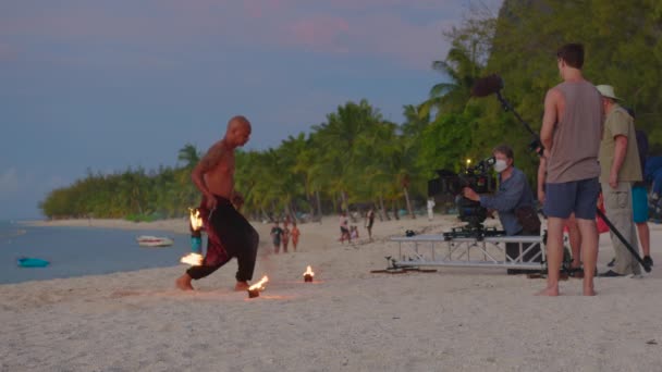 Mauritius, 06 febbraio 2022: Riprese cinematografiche dietro le quinte. Un uomo accende torce di fuoco. Le scintille volano in tutte le direzioni. Produzione cinematografica — Video Stock