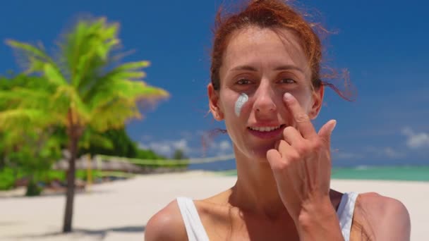晴れた日に女性が顔に日焼け止めを渡す — ストック動画