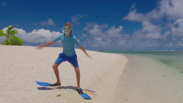 Egy boldog fiú víz alatti álarcban és uszonyok táncolnak és ugrálnak az Indiai-óceán partján. Az öröm és a boldogság fogalma — Stock videók